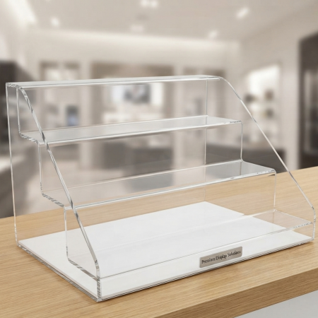 Classic multi-tier clear countertop acrylic display stand on a wooden counter inside a retail store